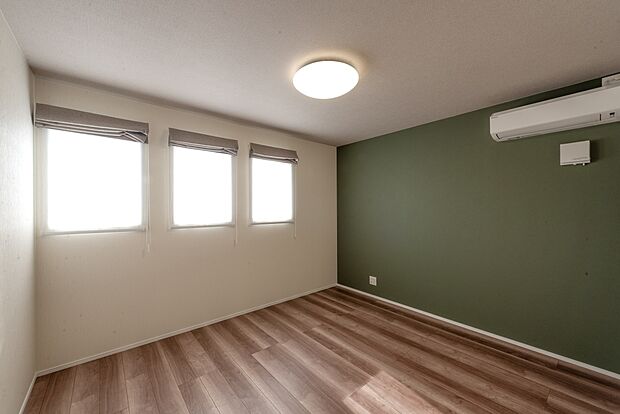 【【2階約7.3帖寝室/A号地モデルハウス】】南面のグリーンのアクセントクロスが爽やかで印象的。リズミカルに並ぶスクエア窓は外観のアクセントとしての役割も果たしつつ、室内からは絵画のように切り取った景観が楽しめます。