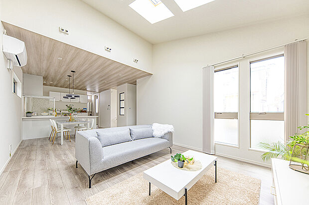 【当社施工例／LDK】
吹き抜けと大きな窓から光が降り注ぐ明るいLDK。白を基調とした空間に木目天井が映え、心地よい開放感を演出します。