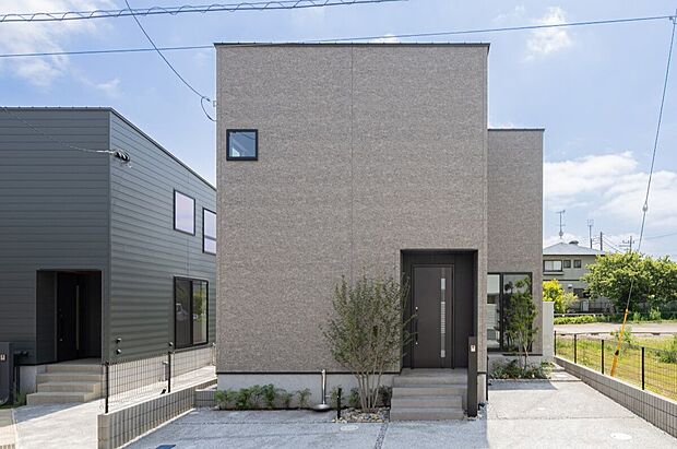 【７号棟】石目調の外壁に黒の玄関ドア。すっきりとした箱型の外観デザインです。駐車スペースは2台分。