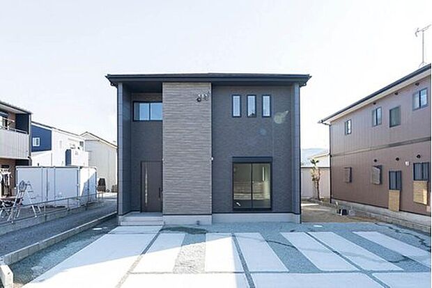  黒と木目のコントラストが美しいデザイン。前面道路も広く、並列3台分のゆとりある駐車スペースを確保しました。大きなミニバンの車庫入れもスムーズで、毎日の送迎や買い出しが楽になります。