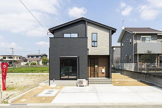 【1号地】ダーク系と木目調のスタイリッシュな2トーン外観。カースペース2台分はゆとりがあって駐車もスムーズ。