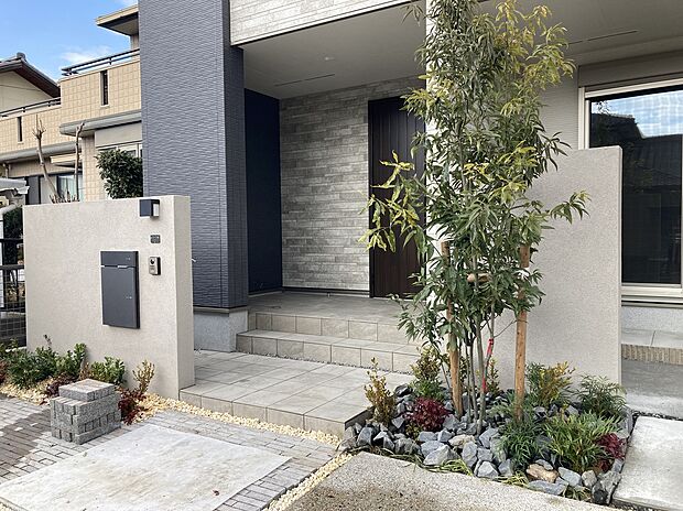 【【B棟　玄関ポーチ】】2Fのバルコニー部分が庇となり、雨の日でも玄関先で落ち着いてお出かけの支度をすることができます。ベビーカーや三輪車など、雨にぬれずに置いておけます。