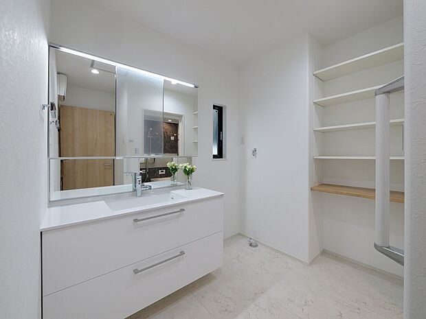 【【E棟 洗面室】】身支度のしやすい、三面鏡とシャワー付きの洗面化粧台を設置。洗面化粧台の収納スペースに加え、可動棚を設けており、タオル類や洗面用品なども整理整頓可能です。