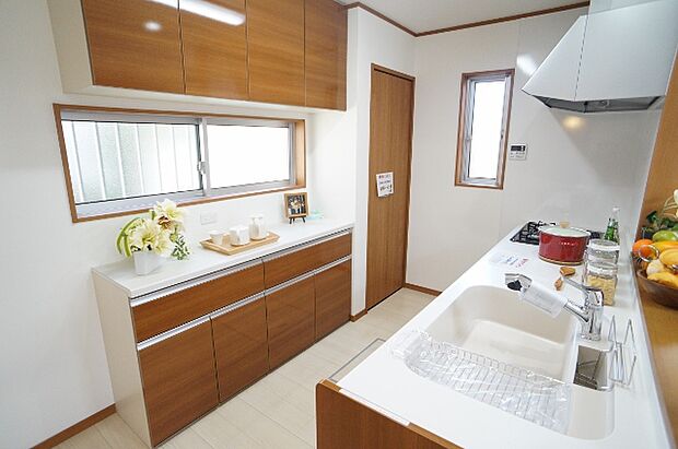 【【LIXIL】システムキッチン-施工例-】落ち着いたカラーのライトウォルナットをチョイス。キッチンとお揃いのローボードも標準仕様。※吊り戸はつきません。