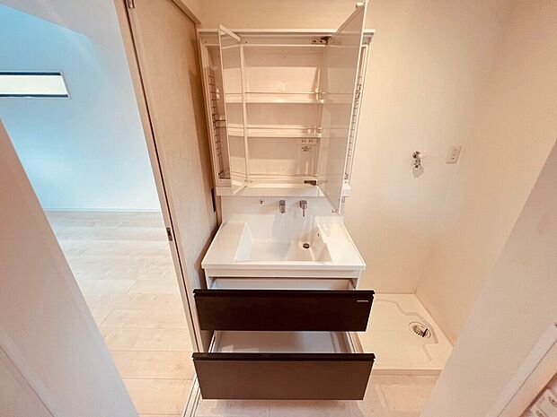 【【施工例】洗面化粧台】三面鏡付きの洗面化粧台は、鏡の角度を調整でき身だしなみチェックも便利。豊富な収納でタオルや小物もすっきり整理でき、使い勝手の良い快適な水回り空間を実現します。