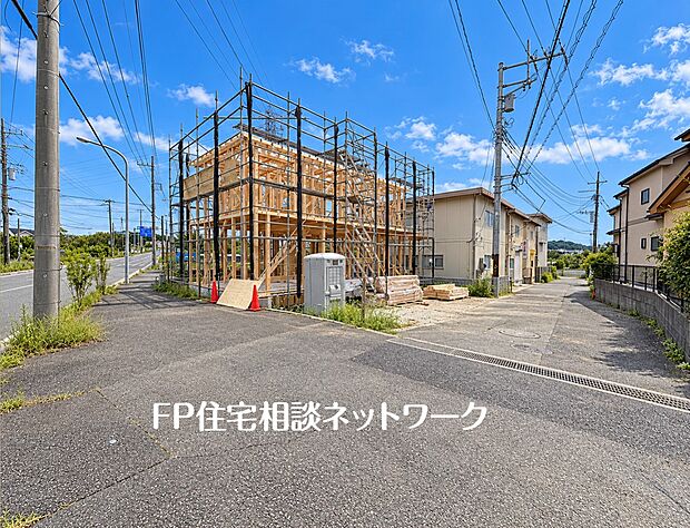 【前面道路含む現地写真】緑豊かな住宅地に佇む、日当たりの良い南道路の物件です。2階建ての構造が組み上がり、理想の住まいが形になっています。車は3台駐車可能ですので、ご家族全員のお車も余裕をもって停められます。