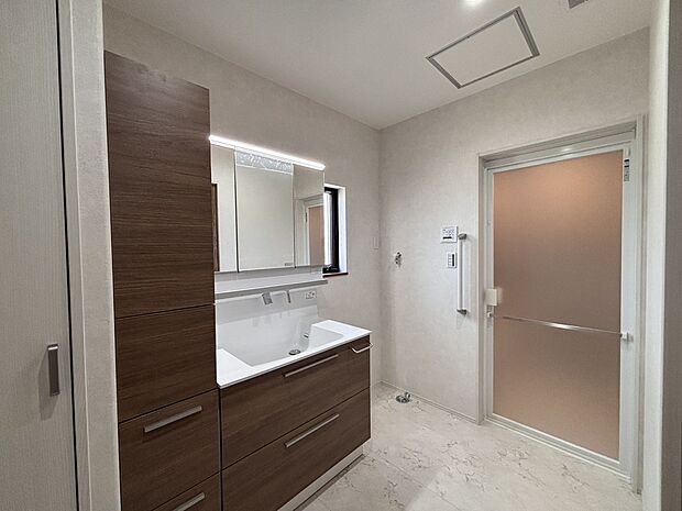 【【H棟 洗面室】】ゆとりある洗面室なら、混雑する朝もゆっくり着脱衣や身支度などができそうです。三面鏡仕様で、混み合う時間帯は横に並んで使用できます。