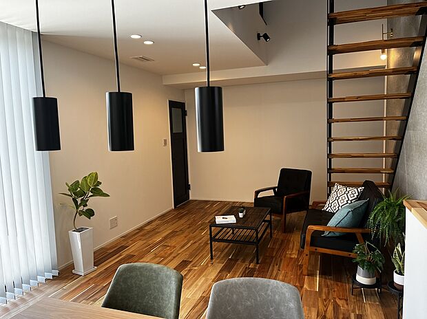 【リビング】無垢床が広がるリビングは、木の柔らかな質感と香りが心を落ち着かせる心地よい空間に。鉄骨階段にすることで軽やかな抜け感と洗練された印象をプラス。素材のコントラストが映えるデザイン性と居心地を両立。