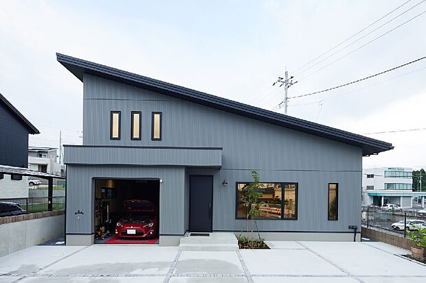 【ガレージのある住まい】片流れ屋根のスタイリッシュモダンな外観。
シンプルなフォルムのため、建物がのっぺりとしないようにパラペットを深めにつくったのがポイントです。（建築実例より）