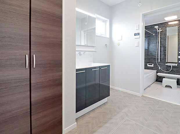 【洗面化粧台】900ｍｍワイドタイプの洗面台を標準仕様としています。洗濯機置き場にはガス衣類乾燥機「乾太くん」が設置できるガスコック付き。