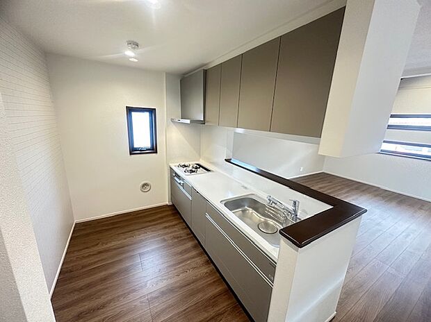 落ち着いたトーンの木目フロアとシックなキャビネットカラーが調和し、上品でモダンな印象を与えます。