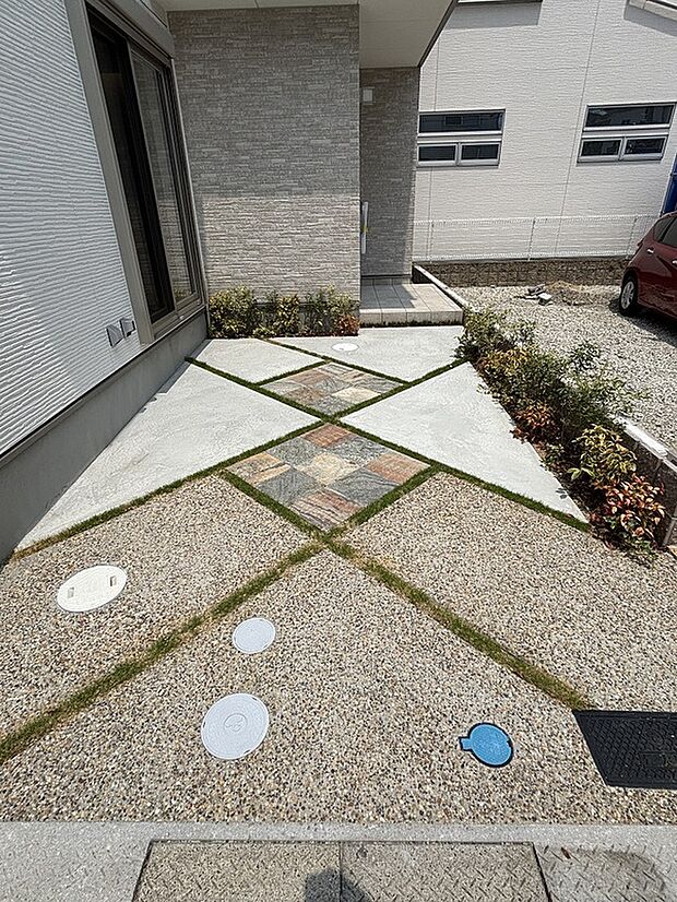 【駐車スペース】石板と植栽で彩られた駐車スペース。ライトも設置してあり、夜間も分譲地全体であたたかみのある街並みとなっています。