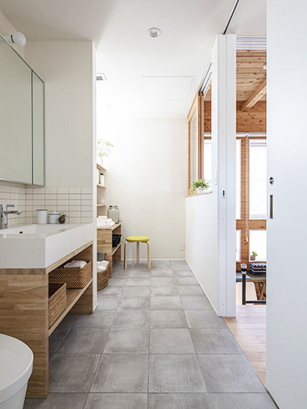 【【プラン例】】浴室、トイレ、洗面脱衣室が一直線に並ぶ。踊り場に面する壁には窓を設けて、開放的に。壁は白、床はセメント調タイルで、家の中の「中と外」の中間的な雰囲気を持つ。