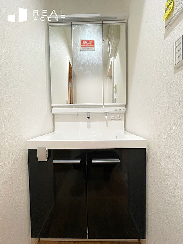 【B号棟洗面化粧台】汚れも一拭きの一体成型カウンターでお手入れ簡単。三面鏡の裏には小物の整理に便利なキャビネットがあり、洗面台周りを綺麗にできます。