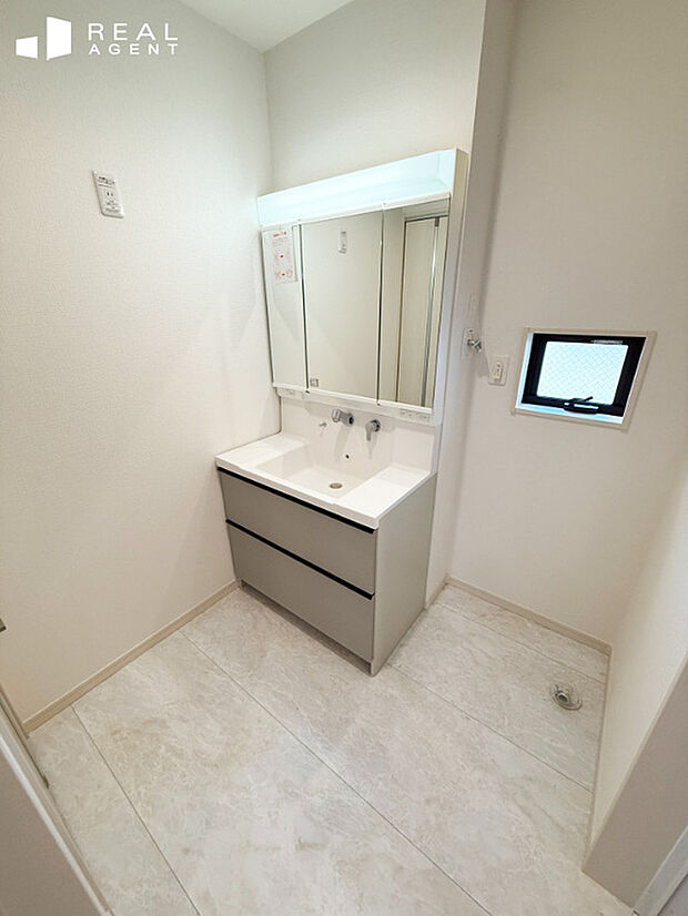 【II-2号棟洗面化粧台】洗濯機を置いても余裕のあるスペース。清潔感のあるパウダールーム、毎日何度も使う場所でもストレスなく使用できます。