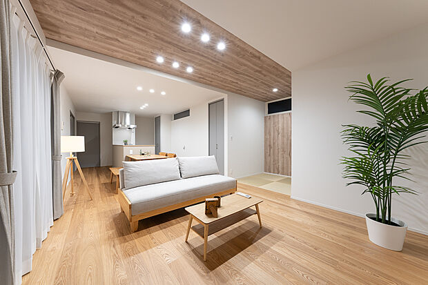 天井を一部上げる事で開放感やデザインをプラス。また、冷暖房効率を考慮して高すぎない設計。南面の大きなサッシから光が差し込み、明るく心地よい空間。