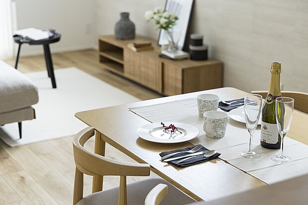 【【1階約17.83帖LDK/1号地モデルハウス】】対面キッチンカウンター前にダイニングテーブルを配置すると、お料理の配膳やお片付けがスムーズです。視界を遮る大きな柱や壁がなく、どこにいても一体感に包まれます。