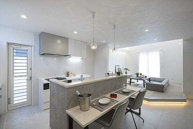 【【1階キッチン/当社施工例】】キッチンはぐるっと囲む事ができ、カウンターを設けたカフェスタイルに。背面の勝手口ドアからも陽光が届き、外へ直接出ることもできます。/建物価格2761.1万円、建物面積96.47m2、3LDK