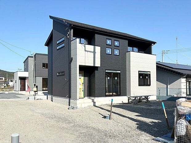 【2号棟:外観】外構工事中。スタイリッシュなブラック×チャコール×グレーの外観。シャープなフォルムが際立つモダンデザインの住まい。大きな窓から明るい光を取り込めます。