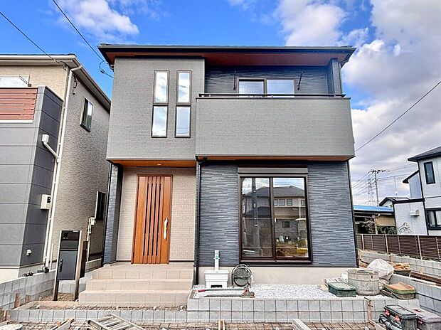 【2号棟　外観】2025年12月6日撮影
シックな色合いで統一された外観が、落ち着いたモダンな雰囲気を演出しています。長く住んでも飽きのこない、シンプルで洗練されたデザインとなっております。