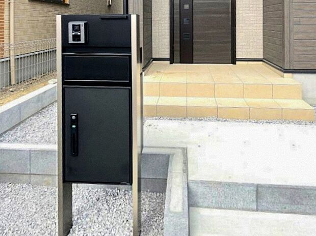 【1号棟：宅配ボックス付き門柱】　　宅配便を無人で受け取れる宅配ボックスを搭載した門柱。時間指定や再配達といった手間を気にせずお荷物を受け取れます。