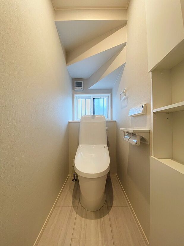 【ベーシアシャワートイレ】フチレス形状やお掃除リフトアップ機能などお手入れのしやすさが特徴。壁設置型のリモコンと2連紙巻き器が備え付けとなっている超節水タイプのシャワートイレです。