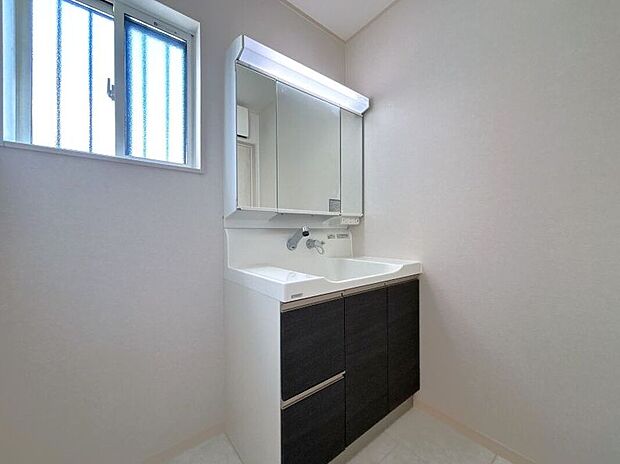 【【3号棟　洗面室】】洗面台は、継ぎ目や凹凸の無いなめらかな曲線で汚れがたまりにくく、日々の簡単なお手入れでキレイが続く人造大理石のボウルです。鏡裏は全面収納場所になっており、電動歯ブラシやシェーバーの充電ができます。