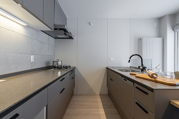 ダイニングの自然な風合いと壁面タイルのコントラストが洗練された印象のキッチン(2025年3月撮影)