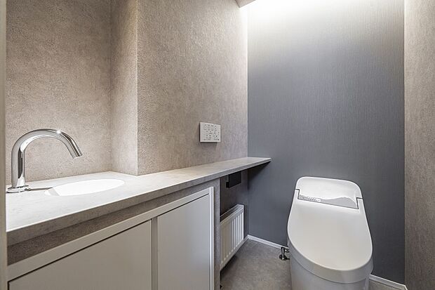 【1階トイレ】カウンターと一体型の手洗い器がホテルライクな印象の1階トイレ(2025年3月撮影)