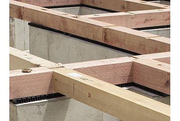 【剛性・耐久性にすぐれた「ベタ基礎」】コンクリートで建物の下一面を支える工法。基礎鉄筋を張り、強度を高めたベタ基礎の耐圧盤を1階の床下全面に施工し、広い耐圧盤の面で建物の荷重を地盤に伝えます。