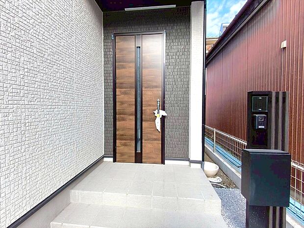 【玄関】清潔感あふれるエントランスと高級感ある玄関扉が出迎えます。思わず「ただいま」と言いたくなるそんな玄関先です。