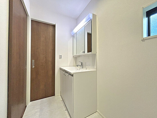 【【Wash Room:1号棟】】機能美とデザイン性を両立させた3面鏡付の洗面化粧台。視覚的に広がり感を持たせるだけでなく、機能的にも優れています。