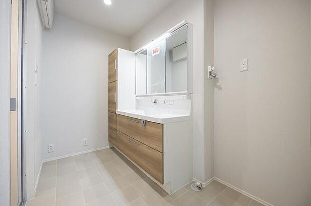 【洗面脱衣室【8号地】(2024年11月撮影)】収納力と機能性が魅力の三面鏡タイプの洗面化粧台を採用。同色扉のトール収納でさらに収納力UP。