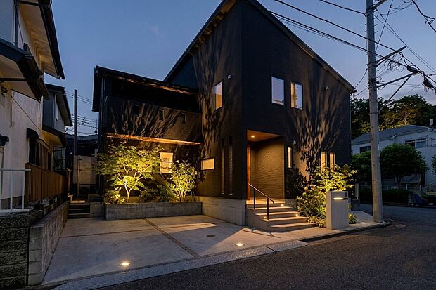 【外観】洗練されたモダンな外観と、緑豊かなシンボルツリーが調和する邸宅。家族みんなが誇らしく思える、笑顔あふれる我が家をここで形に。（一部画像をAI処理し夜景風景や照明等を配置したイメージ画像となります）