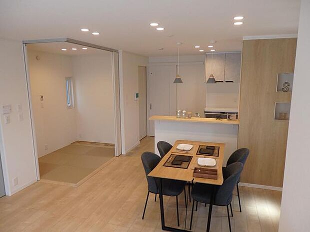 【【B区画】LDK】優しい木の色合いと落ち着いたグレーが印象的な空間です。タタミコーナーもあわせると約20帖の広々LDKとして過ごしていただけます。