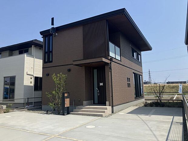 B棟外観/ブラウンの外壁と格子が重厚感と高級感を与えます。植栽の緑が良く映え、印象的。(2025年5月撮影)