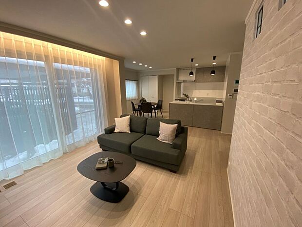 大開口の窓に加え、間接照明によりリビング空間が広く感じられます。（2025年12月撮影）