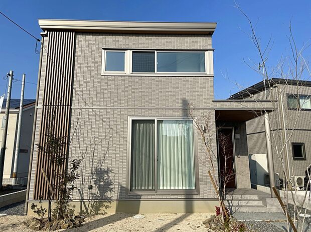 【1号地外観】
重厚感のあるタイル外壁が印象的な外観。深みのある質感が光を受けて美しい陰影を生み出します。木目調の縦格子がやさしいアクセントとなり、上質で落ち着きのある佇まいです。