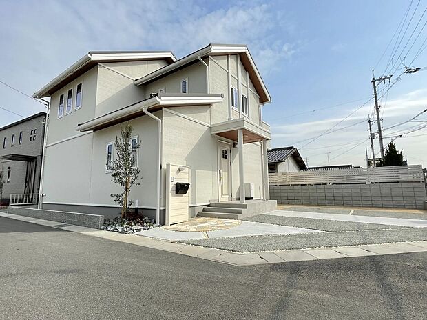 白を基調とした明るい外観に、木目調のアクセントがやさしいぬくもりをプラス。サークル型の石畳アプローチが家族やゲストをあたたかく迎え、ゆとりある駐車スペースも備えた、暮らしやすさに配慮された住まいです。