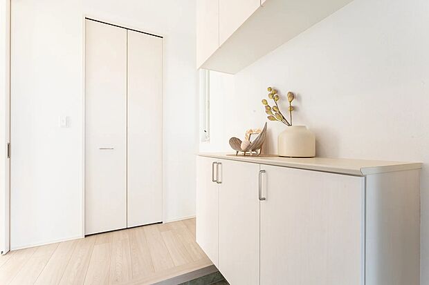 白で統一された明るく清潔感のある玄関空間。シューズボックス上は季節のディスプレイスペースとして活用できます。