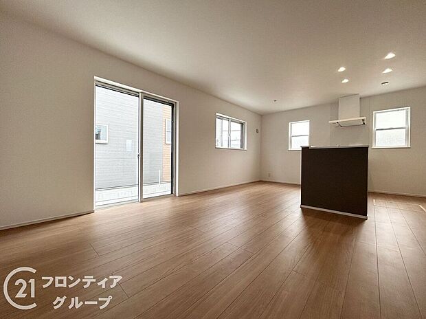 ナチュラルな木目調のフローリングと落ち着いたトーンのクロスが調和したリビング。大きな掃き出し窓が開放感を演出し、外の風景と心地よくつながります。家族との時間も一人の時間も楽しめる理想的な居住空間です。