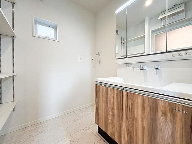 【洗面台・洗面所】三面鏡付きの機能的な洗面化粧台。ノズルが伸びるハンドシャワーでお掃除も楽々。備え付けの収納棚があるため、家具を買い足す必要がなく広々と使えます。