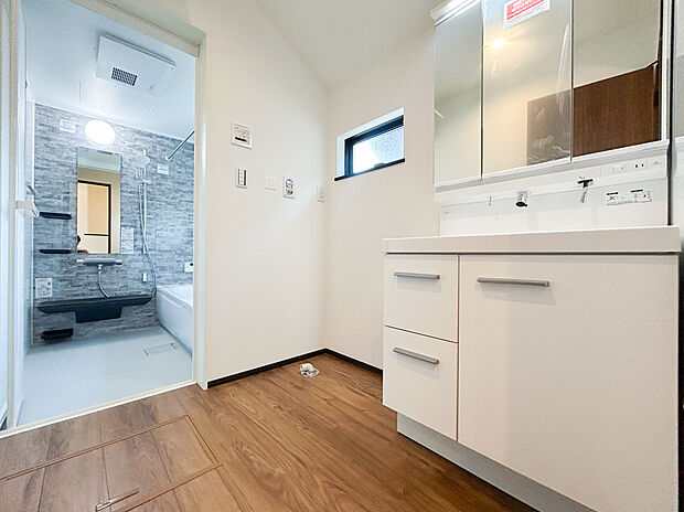 【=洗面脱衣スペース=】三面鏡付きの洗面化粧台は、細かなところまで確認できる使いやすい設備です。収納スペースも鏡の内側にしっかり確保されており、洗面台まわりをすっきりと保てます。(2号棟)