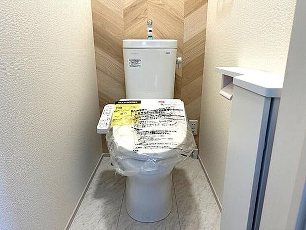 【トイレ】温水洗浄機能付きトイレを採用。アクセントクロスが空間に彩りを添え、清潔感のある空間に仕上がっています。