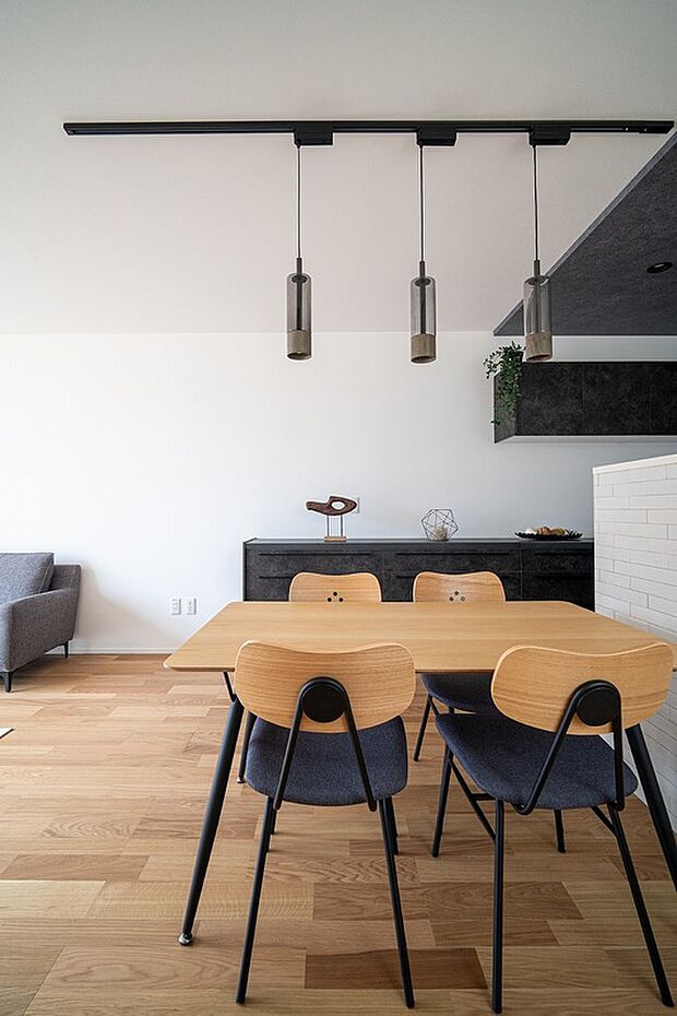 【【A-5】■ダイニング】黒いライティングレールに吊るされた3つのペンダントライトが、このダイニングエリアを効果的に照らしています。