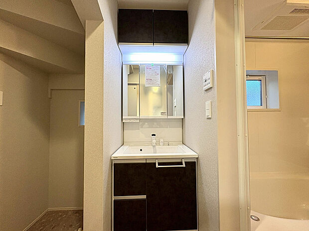 【5号棟 洗面室】三面鏡裏収納と吊戸もあり、細かいものからストック品まですっきり収納することができます。