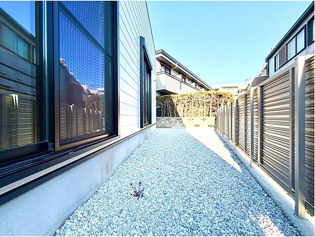 【現地外観写真】陽光が降り注ぐ明るい敷地は、白い砂利敷きで清潔感あふれる空間。手入れも簡単で、お子様との外遊びも安心です。