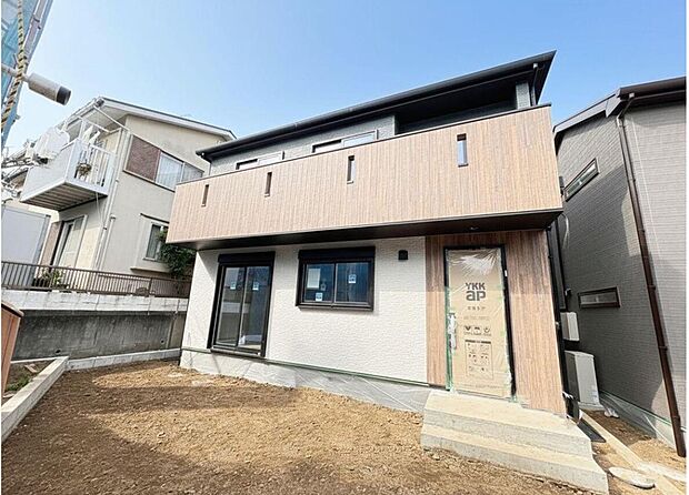 【現地外観写真】新築の美しい外観が目を引く住まい。木目調のデザインが温かみを添え、ご家族を優しく迎えます。