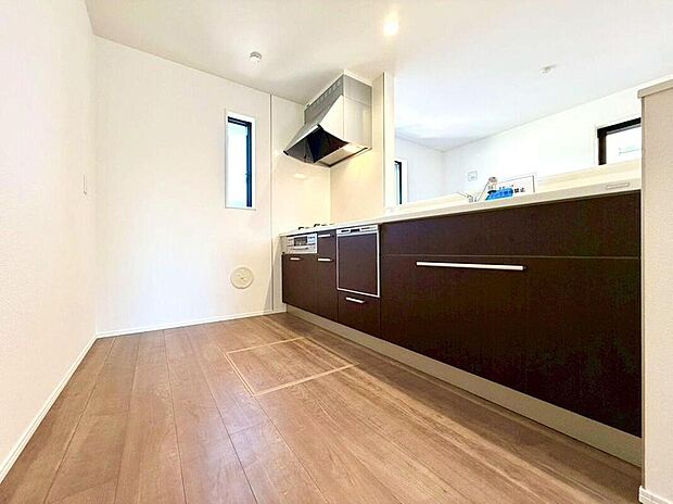 【キッチン】洗練されたダークブラウンのシステムキッチンは、広々とした調理スペースと充実した収納が魅力です。家族の会話が弾む空間で、お子様と一緒に料理を楽しむ時間も増えそうですね。