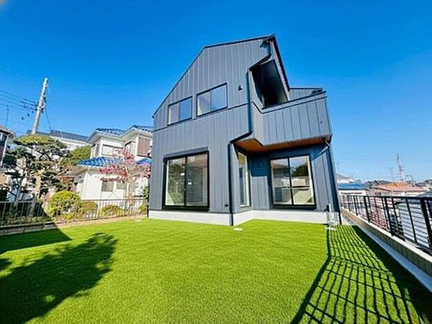 【◇◆外観◆◇】青空に映えるスタイリッシュな外観と、広々とした庭が魅力。高台ならではの開放感に包まれながら、お子様の遊び場やBBQなど家族の夢が広がります。※人工芝はCGです。